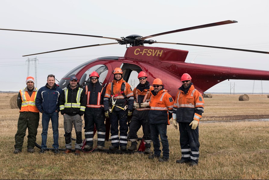 Team in front of a helicopter
